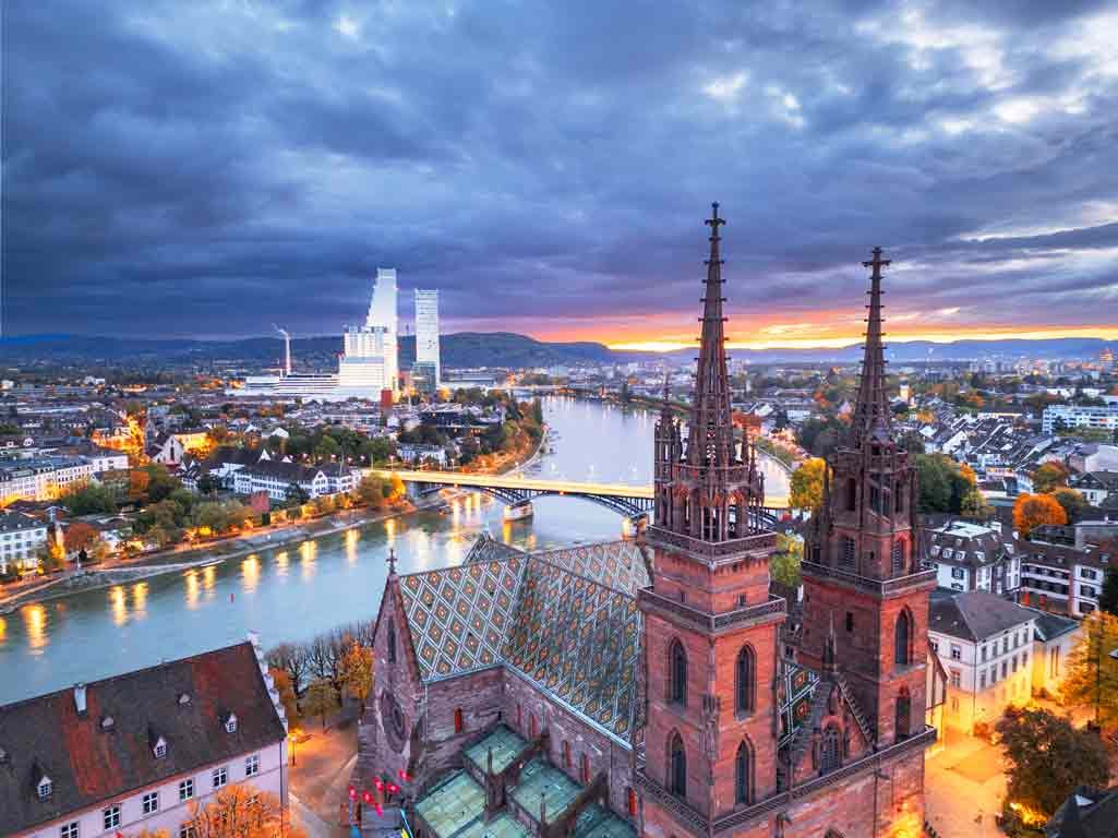 Aerial shot of Basel showcasing the Munster, the Rhine River, the old town, and the Roche Towers.